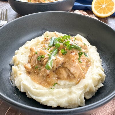 plate of mashed potato topped with honey mustard chicken