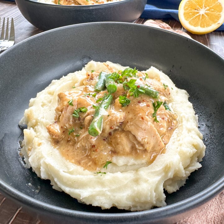 plate of mashed potato topped with honey mustard chicken