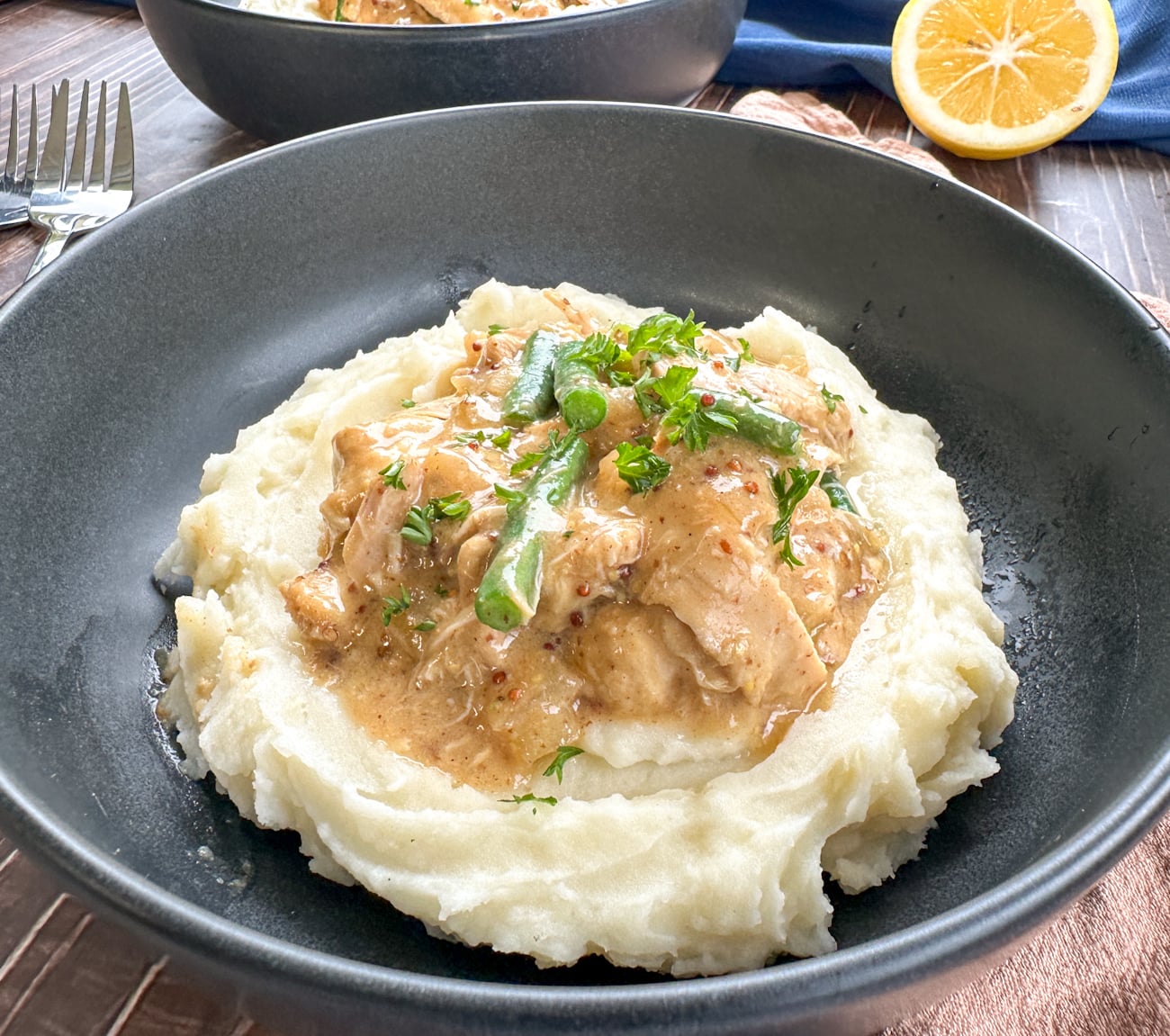 plate of mashed potato topped with honey mustard chicken