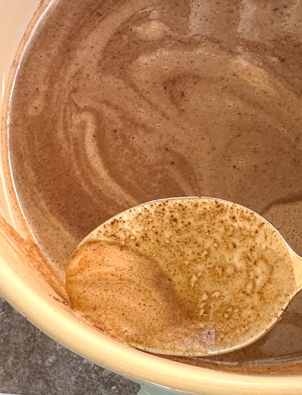 scooping off any frothy bubbles from the top of the chocolate custard