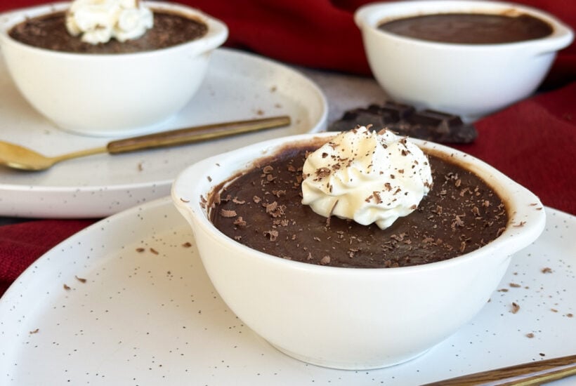 Slow Cooker Silky Chocolate Pots in white ramekins with cream and shaved chocolate