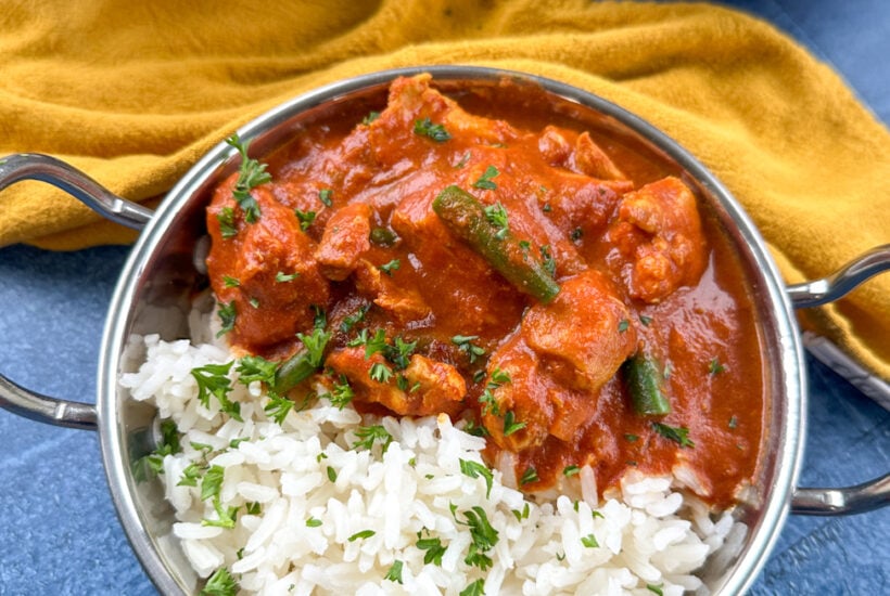 Bowl of tomato chicken curry over rice.