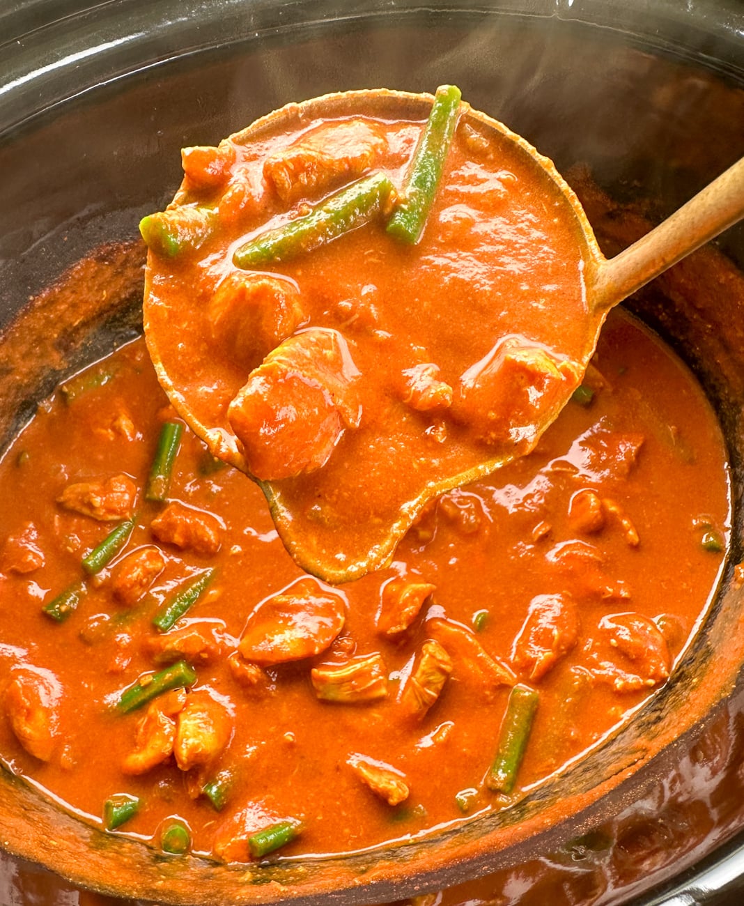 ladle full of tomato chicken curry