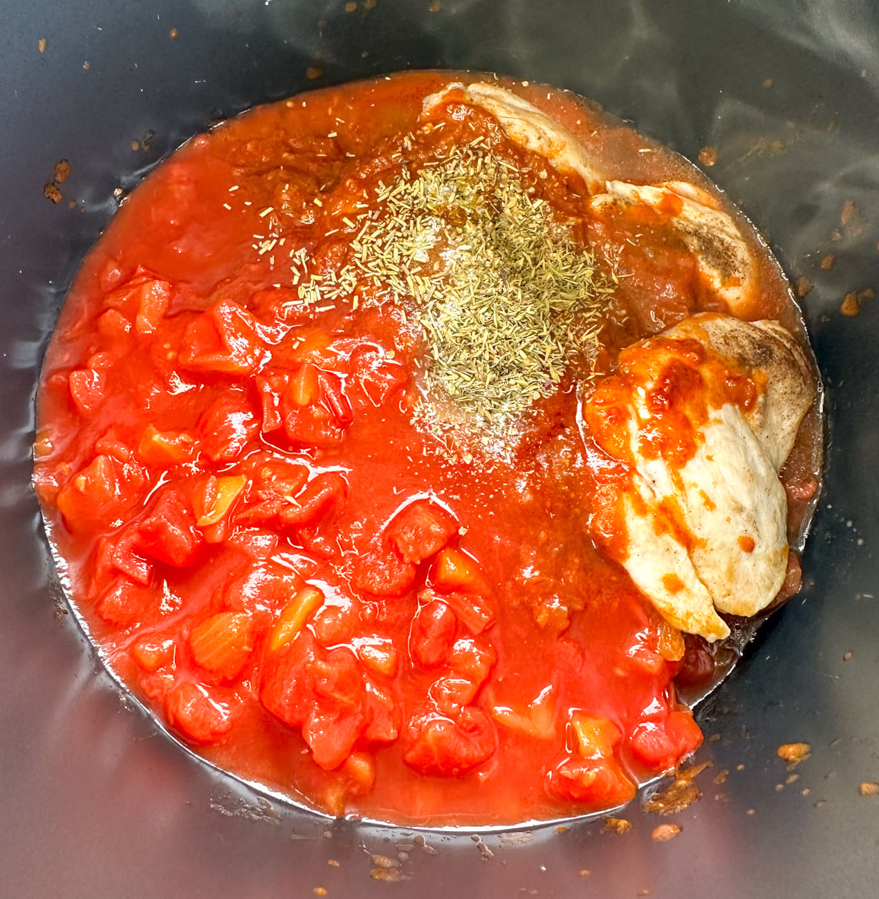 adding everything to the slow cooker for chicken cacciatore