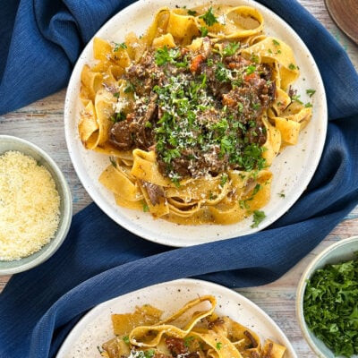 Plates of beef ragu with parsley and parmesan