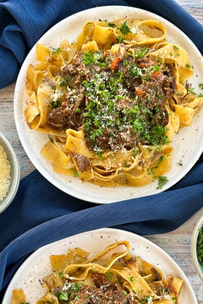 Plates of beef ragu with parsley and parmesan