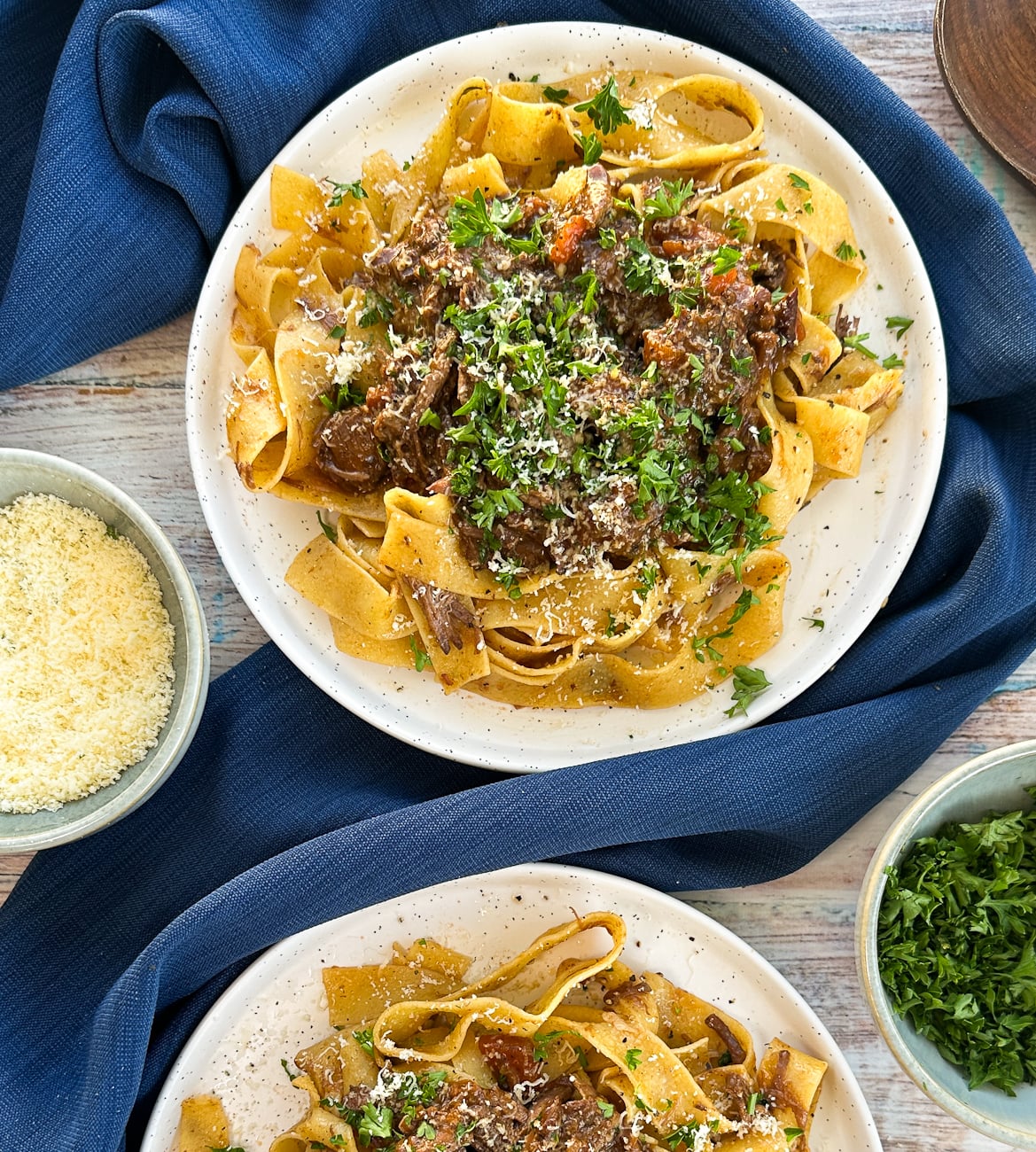 Plates of beef ragu with parsley and parmesan