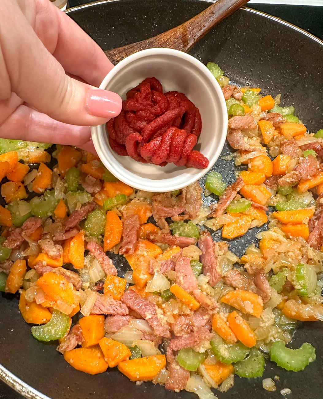 adding the tomato paste to the bacon and Soffritto