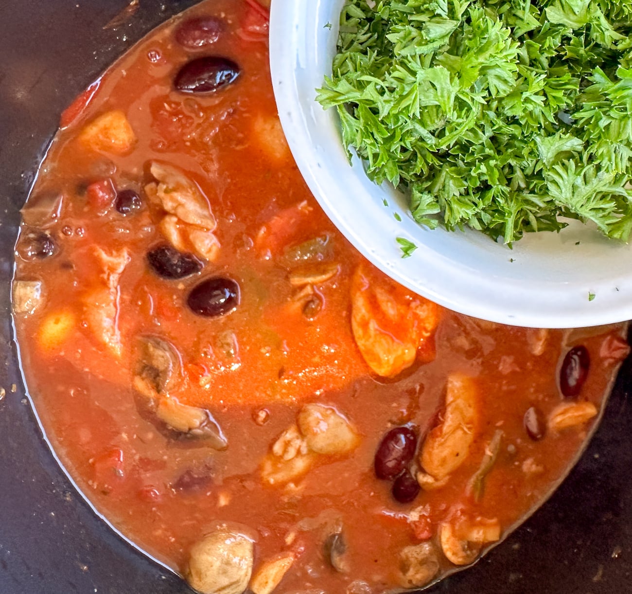 adding parsley to the finished dish