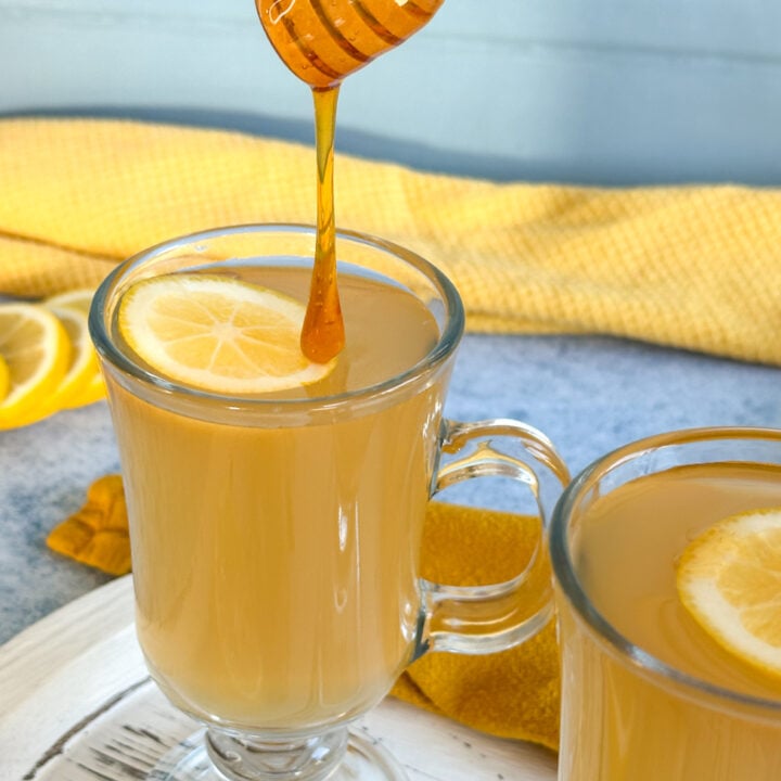 adding honey to a lemon honey ginger drink