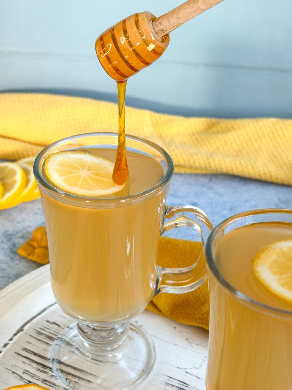adding honey to a lemon honey ginger drink