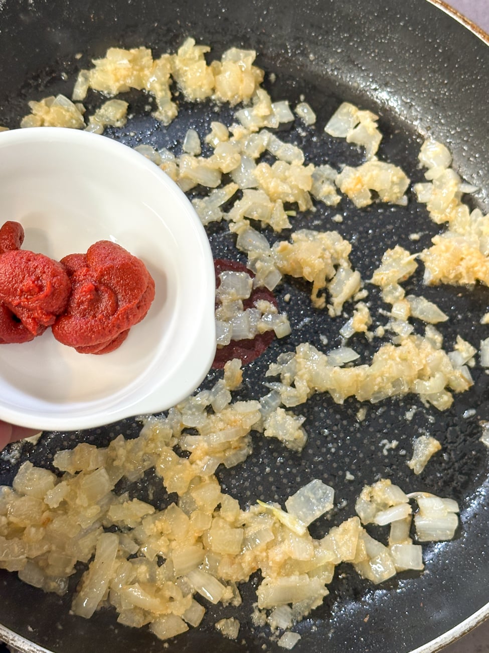 add the tomato paste to the onion and garlic to build flavour