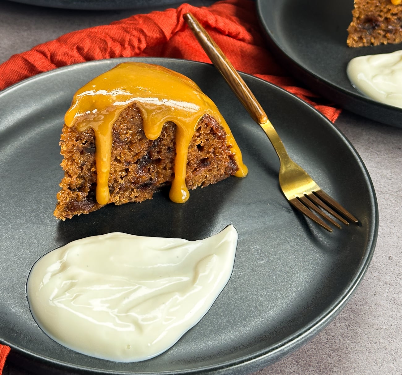 slice of sticky date pudding with caramel drizzle and a swirl of yoghurt.