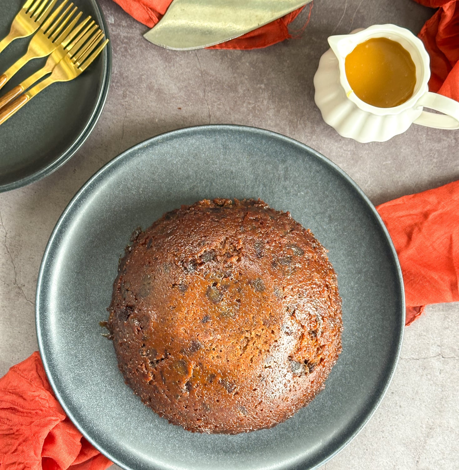 steamed sticky date pudding turned out onto a serving plate to serve.
